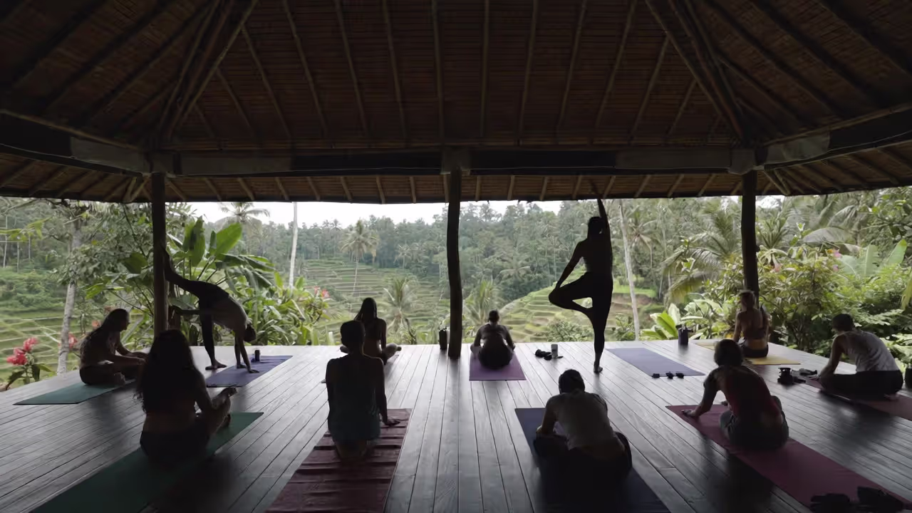 Yoga class in open-air shala in Bali overlooking rice terraces