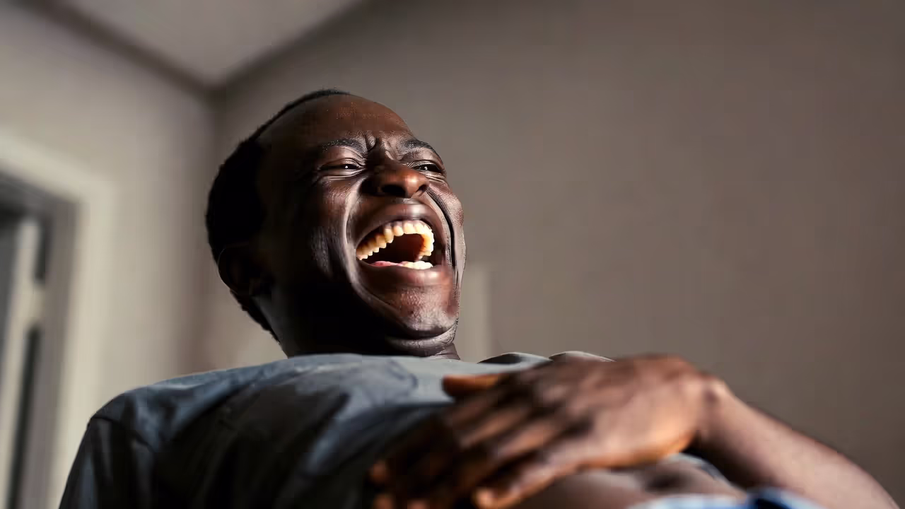 Person laughing deeply with hand on abdomen, illustrating stress relief and breathing benefits.