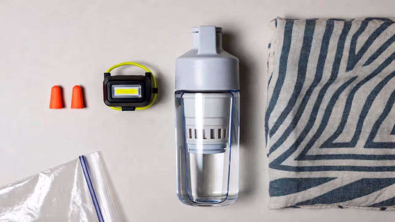 earplugs, headlamp, filtered water bottle, and a scarf with zip bags.