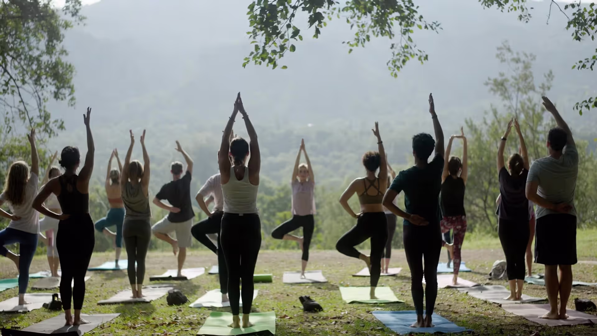 Small outdoor yoga retreat with mixed-level participants practicing together.